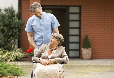 Pflegeassistenz hilft Seniorin im Rollstül